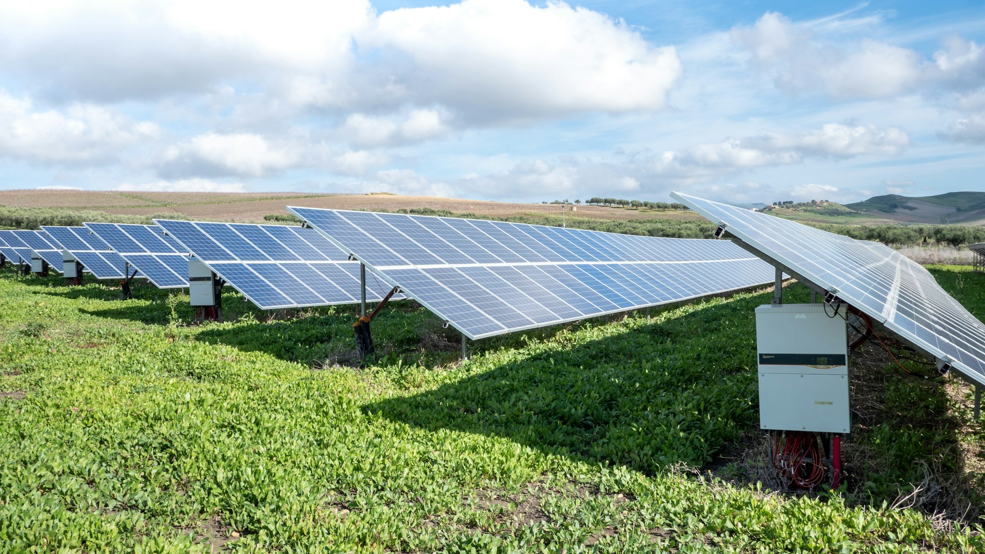 Solar panel field under a bright sky